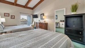 A bedroom with two beds, a dresser, a TV, and a plant.