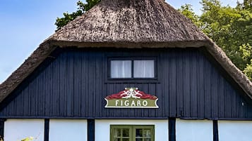 Un edificio tradicional con techo de paja y un letrero que dice "FIGARO".