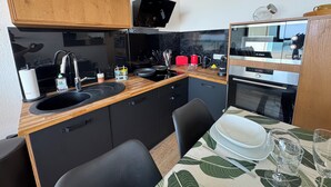 A compact kitchen with a sink, stove, and a Bosch oven.