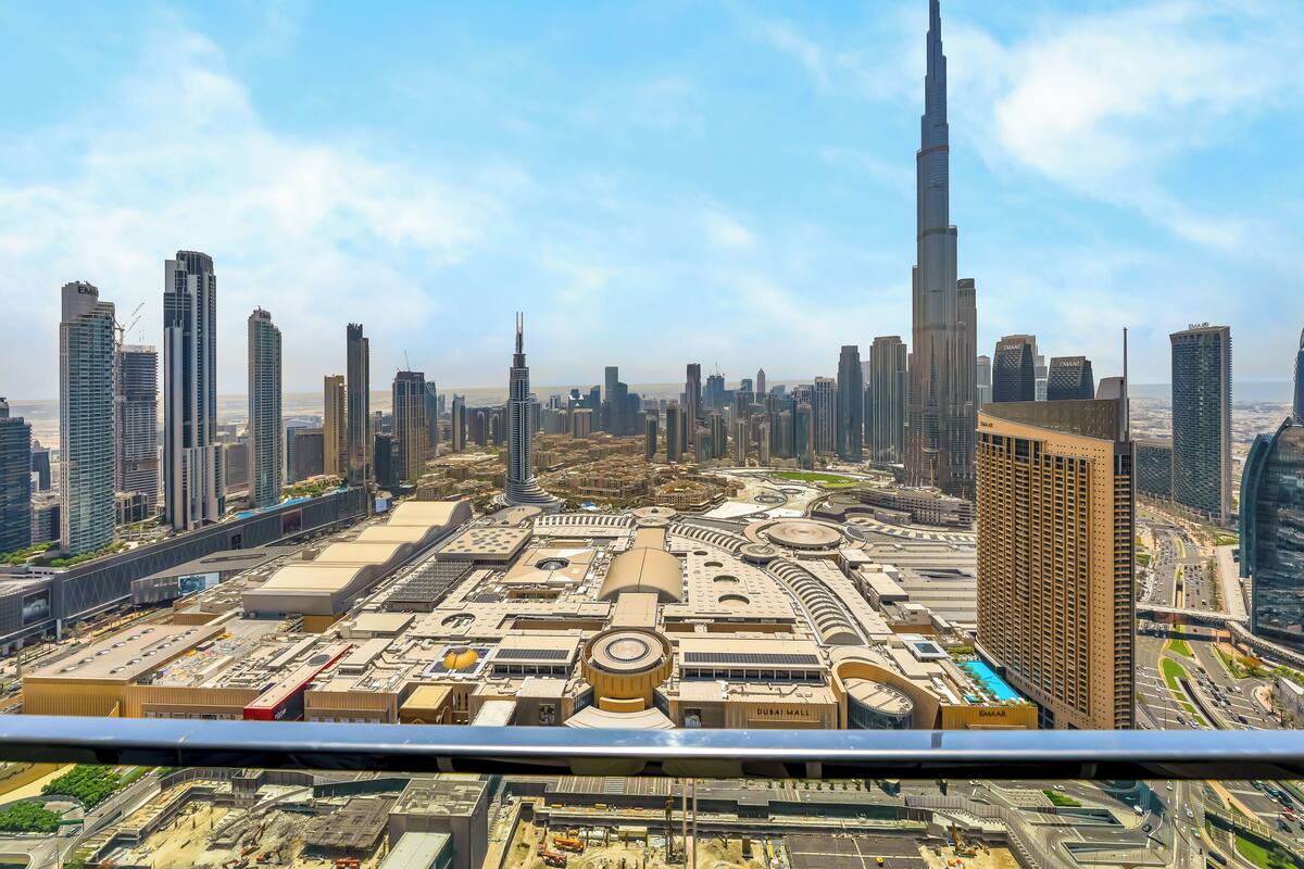 A cityscape with prominent skyscrapers, including the Burj Khalifa, and a view of Dubai Mall.