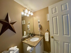 A bathroom with a sink, mirror, towel rack, and a star decoration on the wall.