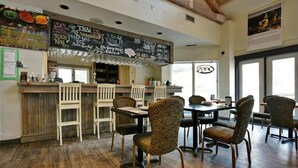 A restaurant interior with a wooden bar, patterned chairs, and a chalkboard menu. - Quiet Hillside Studio (Blue Mountain)