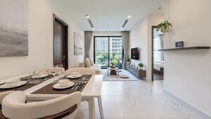 A modern living room with a dining area, a sofa, a TV, and a large window with a city view.