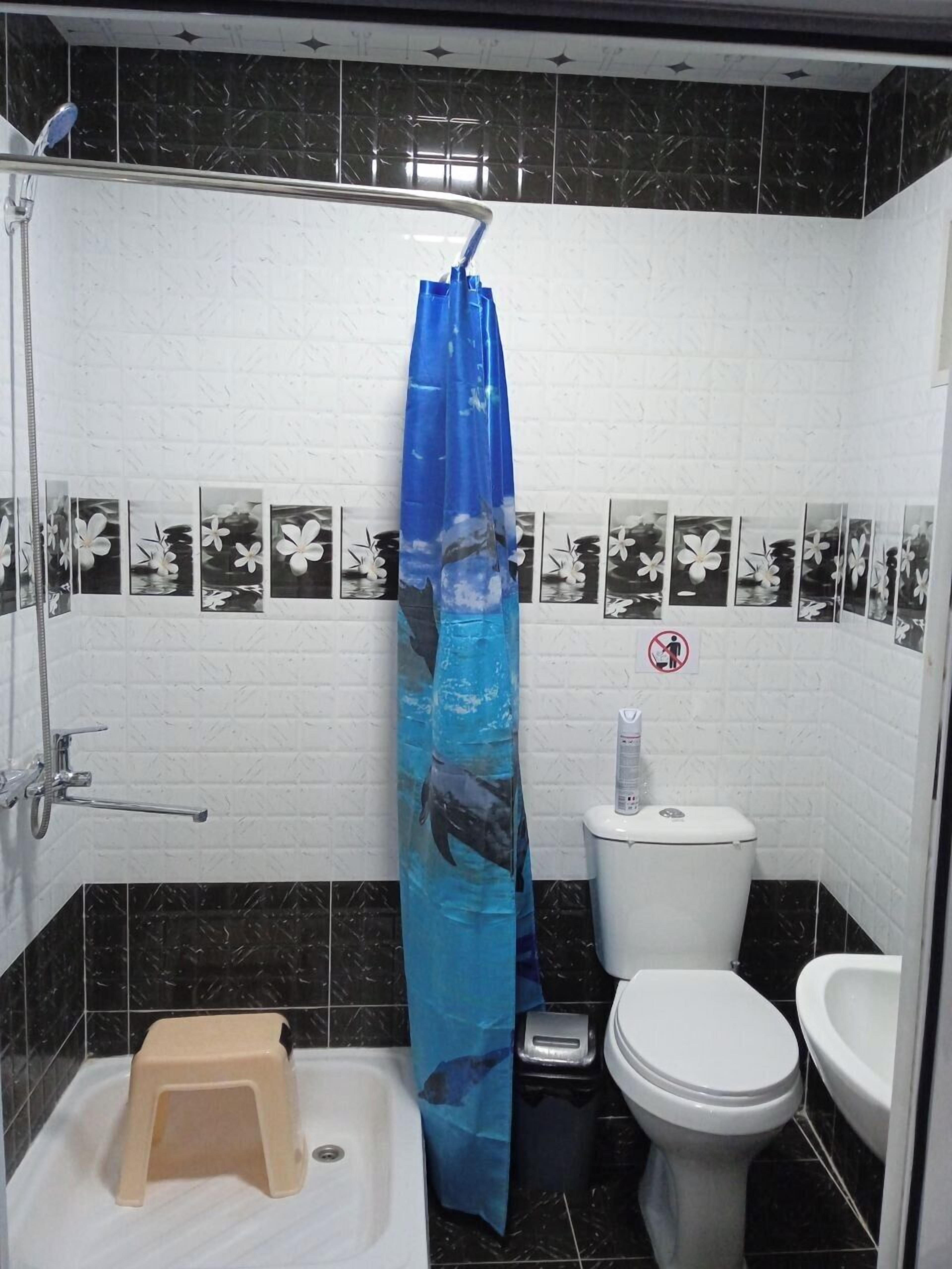 A bathroom with a shower, toilet, and sink.