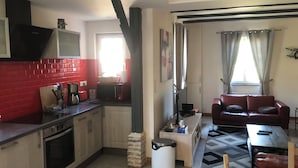 A compact living space with a kitchen, a dining area, and a seating area.