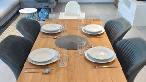 A dining table set for six with plates, cutlery, and glasses.