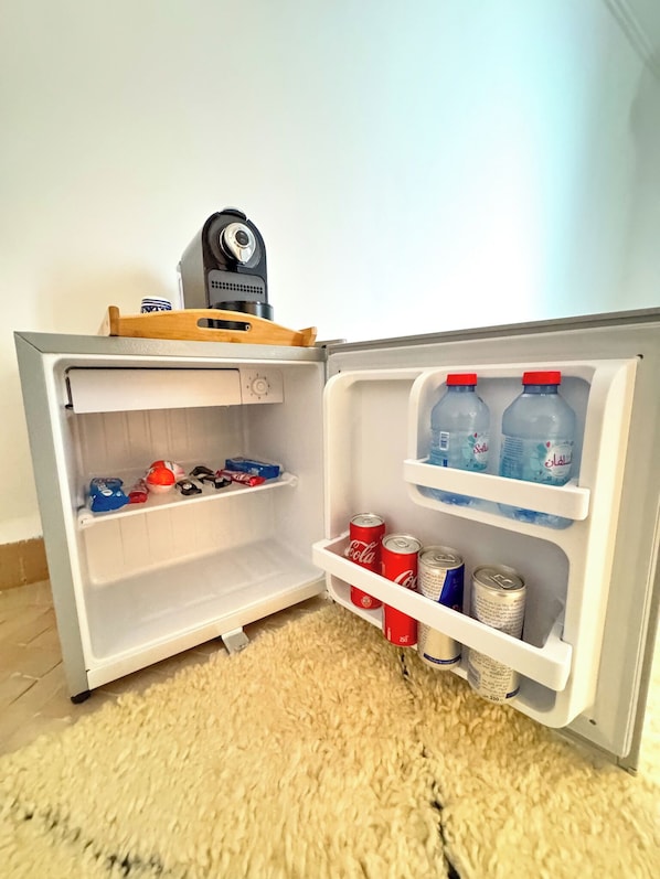 A small refrigerator with a camera on top, containing soda cans and bottles. - Riad  Timrad (Fès)