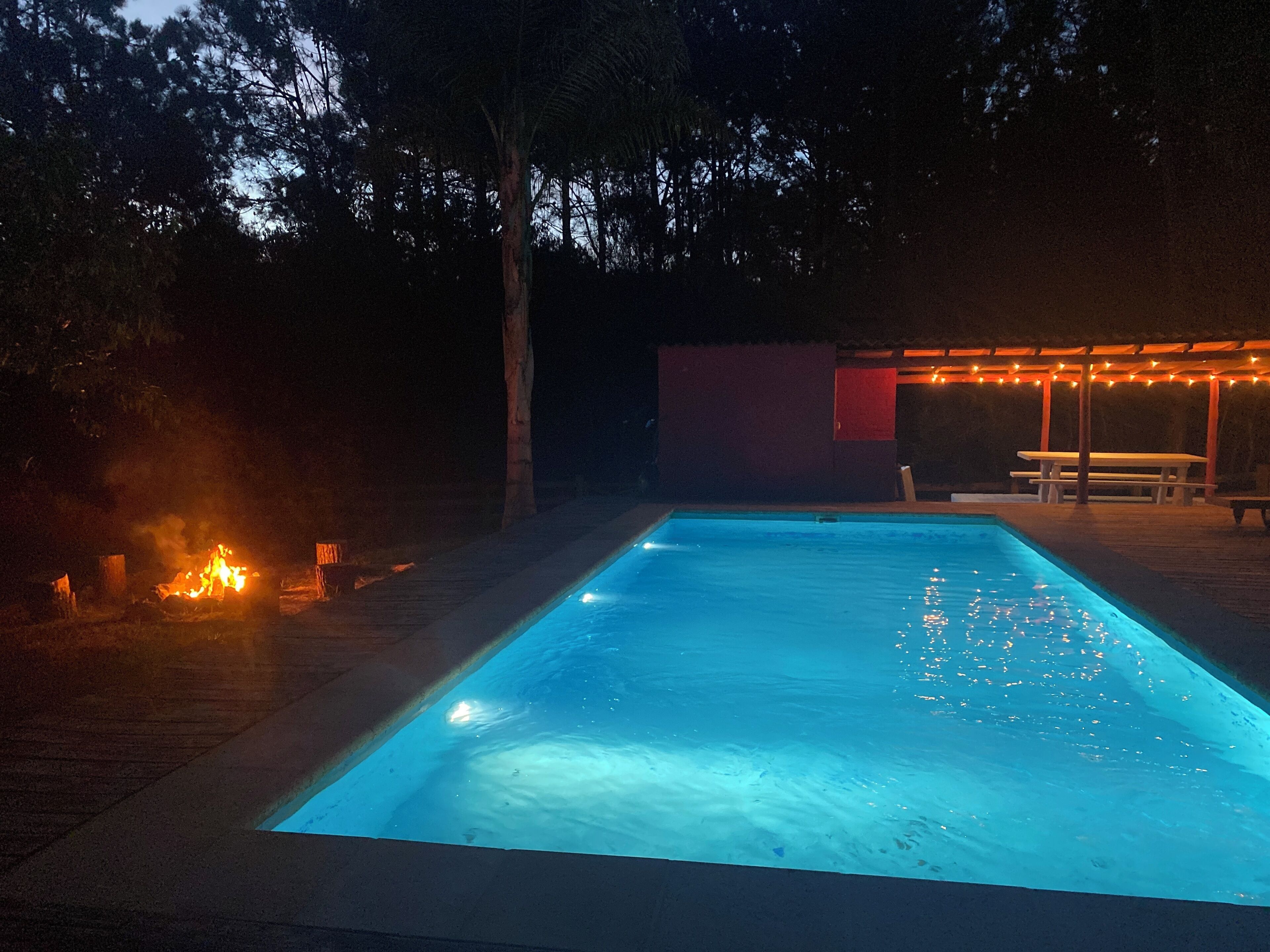 A rectangular pool with clear blue water, surrounded by a deck.