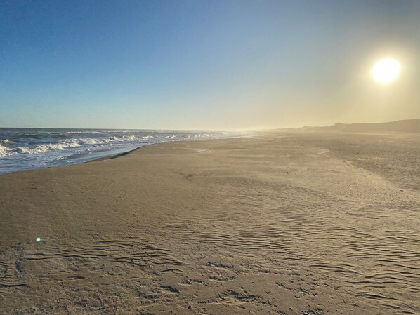 Una playa con olas y cielo despejado.