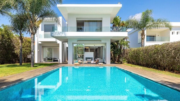 Una casa moderna de dos pisos con una piscina delantera.