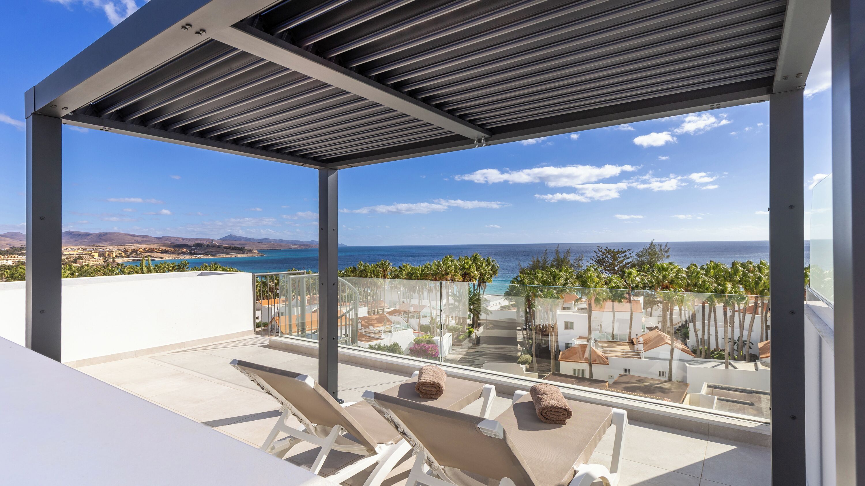 Un balcon moderne donnant sur la mer et les montagnes.