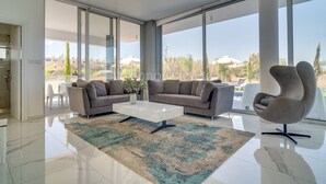 Un salon moderne comprenant un canapé, une table basse et un fauteuil original.
