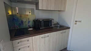 A compact kitchen with a microwave, toaster, and sink. - Shell on the Rhön beach with whirlpool (Wartmannsroth)