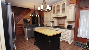 A kitchen with wooden floors, a central island, and a built-in stove. - Historic Main Street Getaway (Leola)
