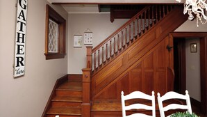 A wooden staircase with a sign reading "GATHER here" on the wall. - Historic Main Street Getaway (Leola)