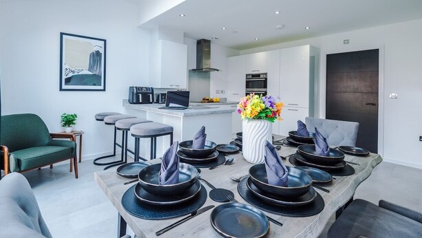 A modern kitchen with white cabinets, a built-in oven, and a black stove.