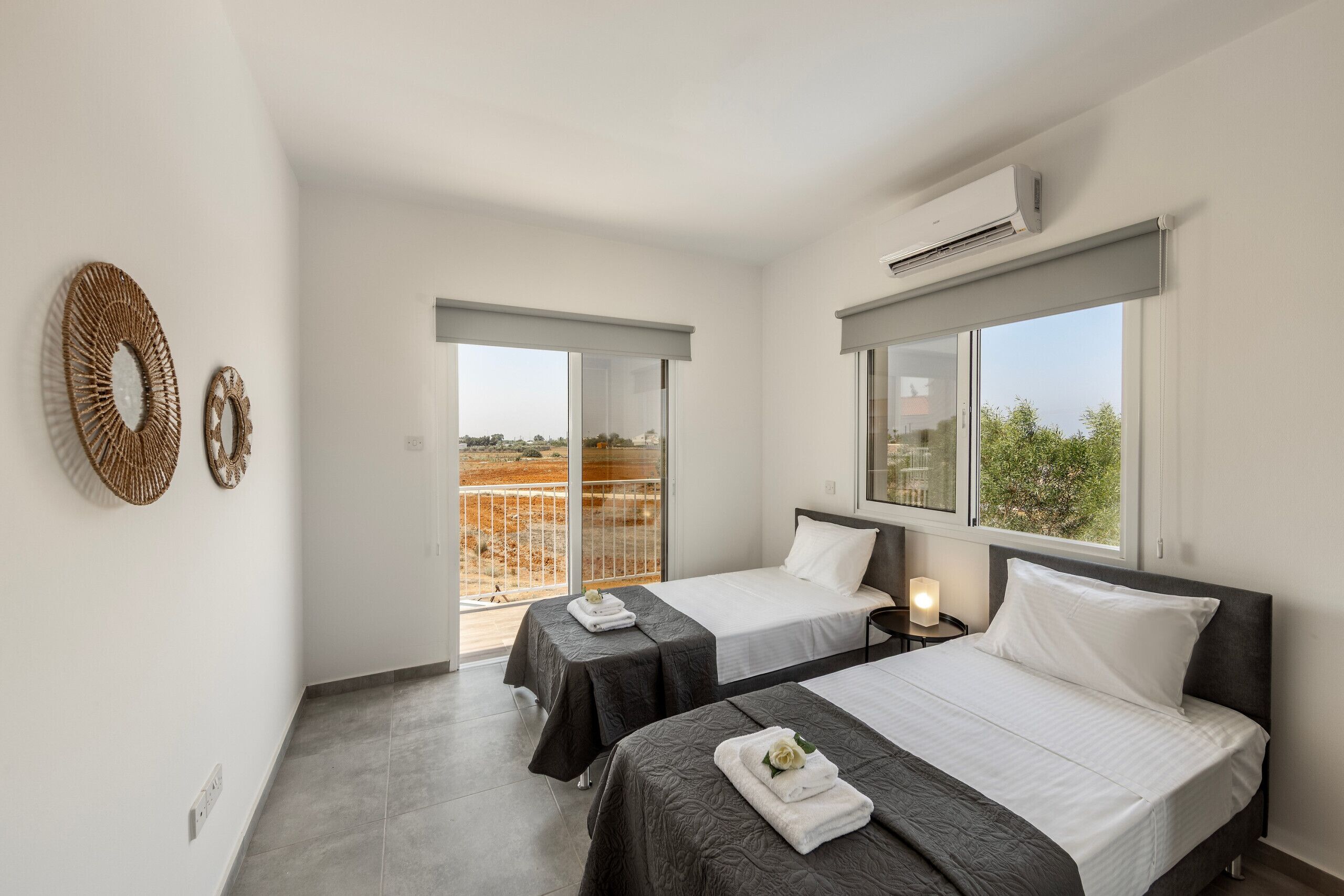 Habitación de hotel con dos camas, un balcón y un ventanal grande.