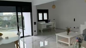 Un salon moderne comprenant un coin repas, une cuisine et un balcon avec vue.