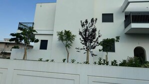 Un bâtiment moderne doté d’une façade plate, de nombreuses fenêtres et d’un balcon.