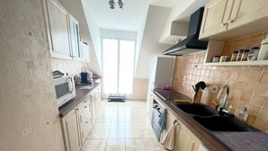 A kitchen with a microwave, stove, sink, and cabinets. - Spacious apartment for 6 people with balcony, Sarzeau (Sarzeau)