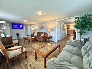 A living room with a sofa, chairs, a coffee table, a TV, and a plant. - 6BD House• Budget Friendly • Sublevel Pub • Patio • BBQ (Xenia)