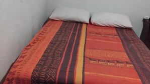 A small, single-bed room with a patterned bedspread and two pillows. - Festival apartment (Avignon)
