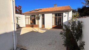 A house with a tiled roof, large windows, and a gravel driveway. - Large family home 150 m from the beach, large well-equipped kitchen (Châtelaillon-Plage)