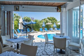 A poolside area with lounge chairs, umbrellas, and a pool.