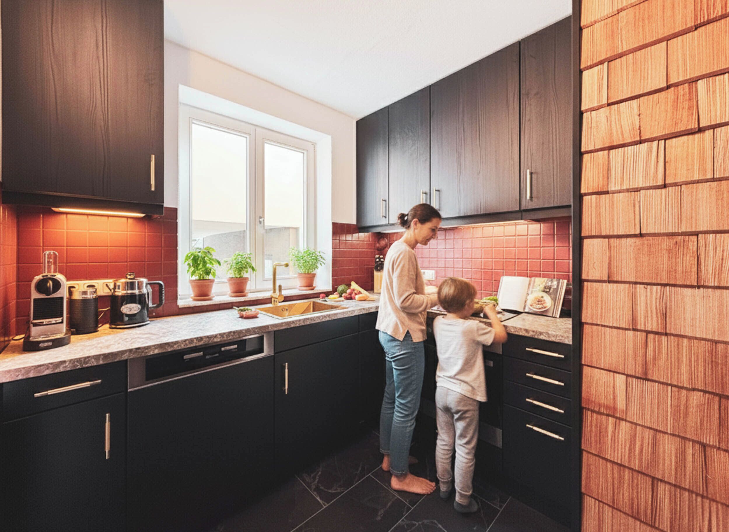 A modern kitchen with dark cabinets, a window, and a countertop with potted plants.