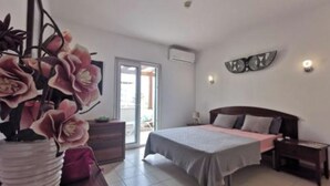 Una camera da letto con un letto, comodini, una cassettiera e una pianta in vaso.