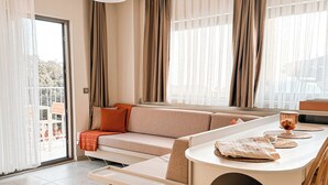 A modern living room with a sofa, dining table, and chairs. - Katana Suites Kaş (Kas)