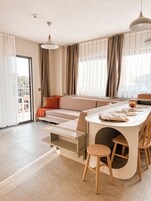 Una sala de estar moderna con un sofá, una mesa de comedor y sillas.