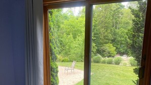 Une chambre avec une grande porte-fenêtre coulissante donnant sur un jardin.