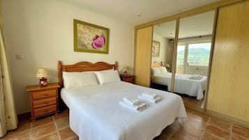 1 dormitorio y tabla de planchar con plancha