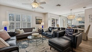 A modern living room with a sofa, coffee table, and a ceiling fan.