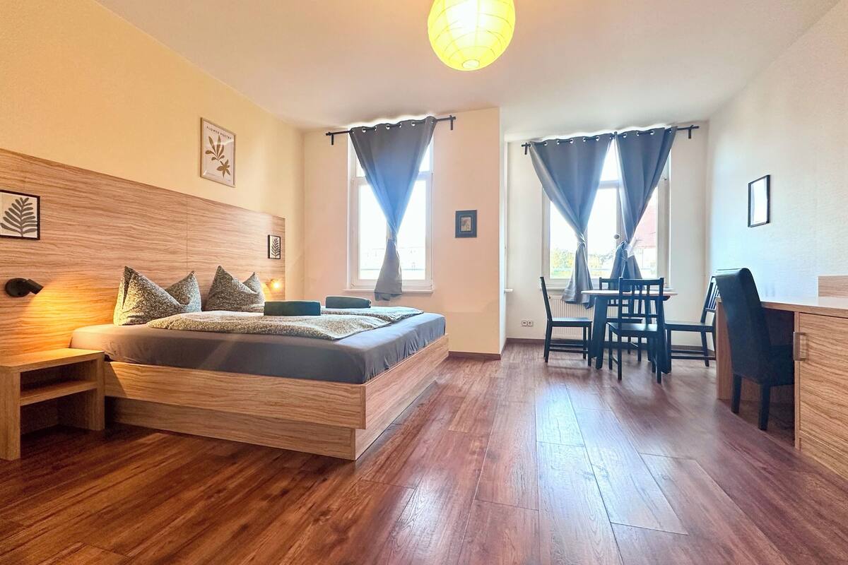 Una camera da letto moderna con un letto in legno, comodini, una scrivania e una sedia.