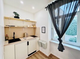 Habitación básica doble, vistas al patio | Cocina privada | Frigorífico, placa de cocina y máquina de café espresso