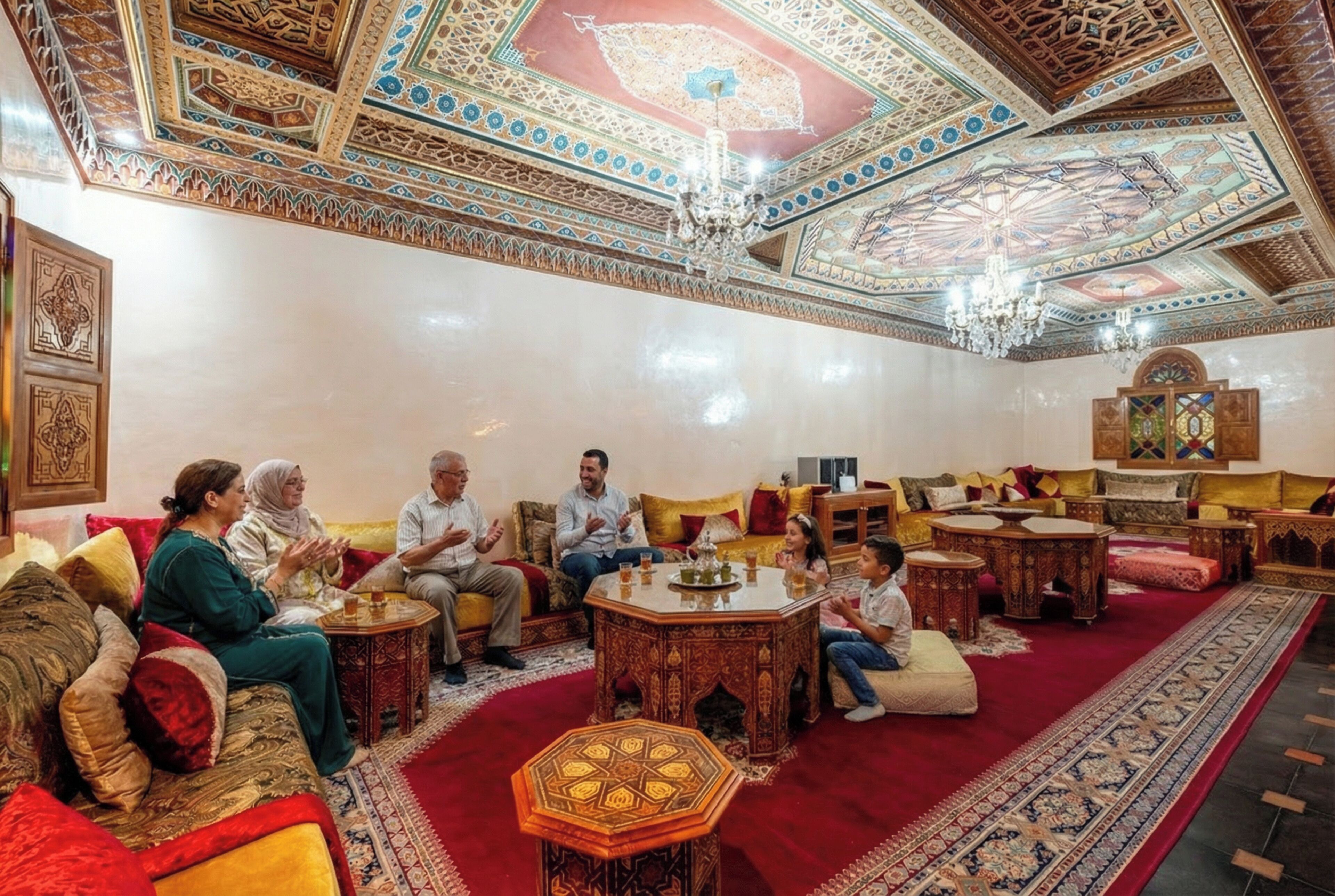 A room with ornate ceiling, traditional furniture, and a central coffee table.