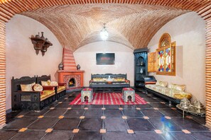 A room with a sofa set, a fireplace, a wall-mounted TV, and a decorative wall. - Spacious 5-bedroom villa in charming Marrakech with WiFi, AC, Private Pool (Marrakech)