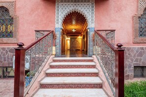 A staircase with ornate metal railings and a patterned wall.
