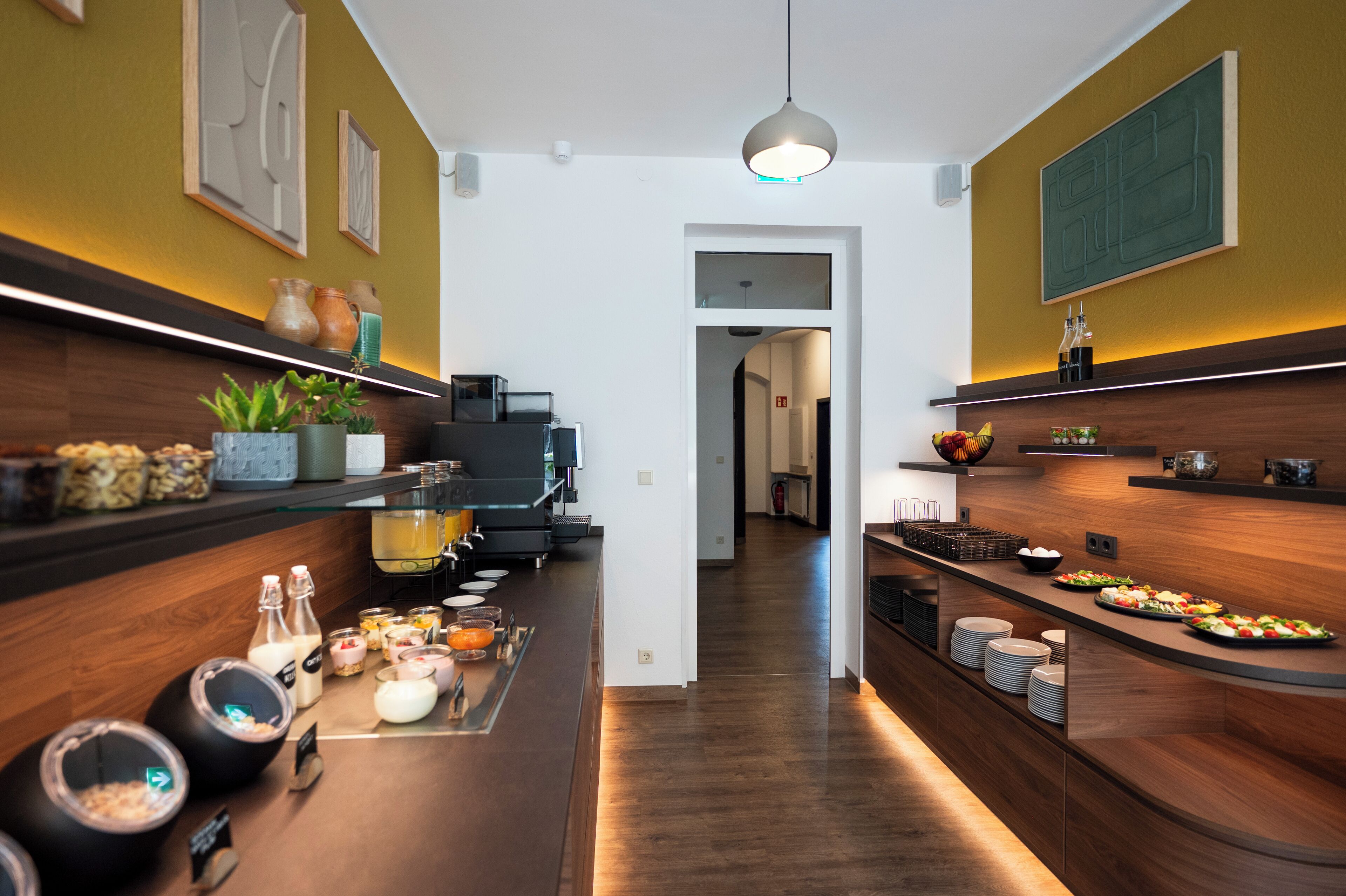 Une cuisine moderne avec des plans de travail en bois, un îlot central où sont disposés des aliments et une vue sur la salle à manger.