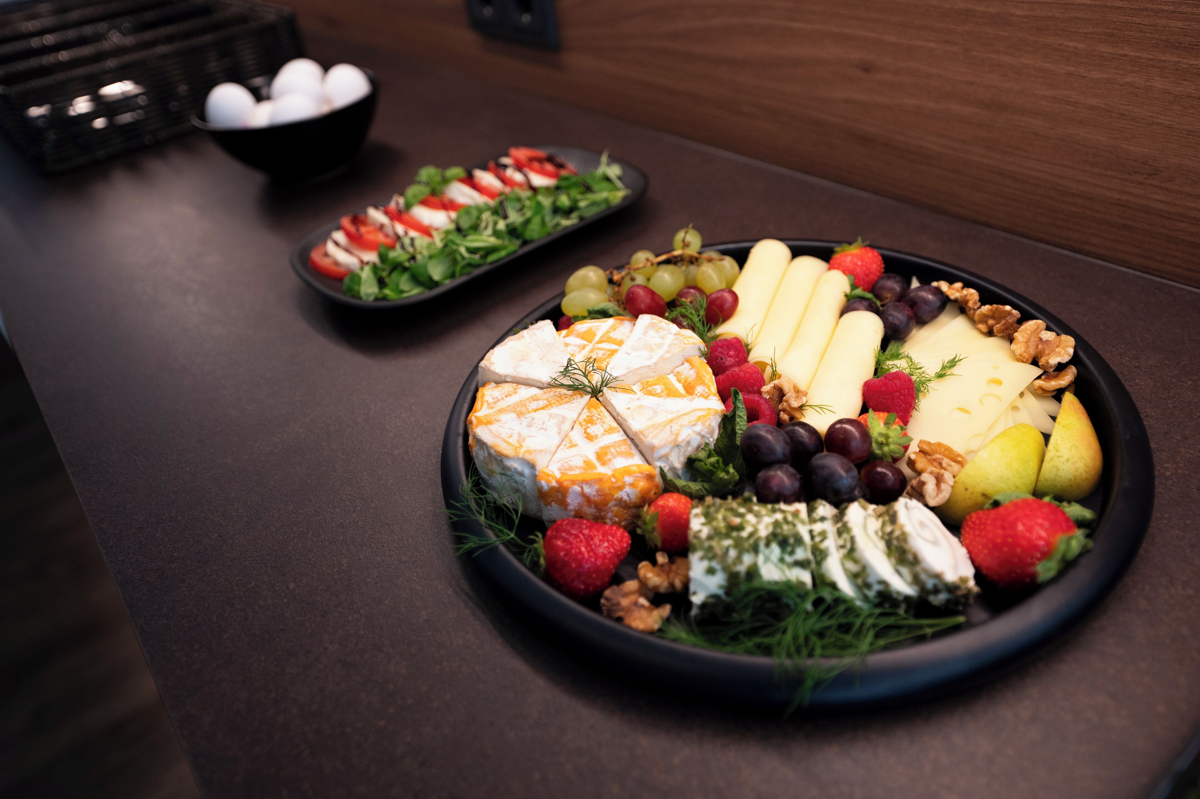 Une table garnie de divers aliments, notamment du fromage, des fruits et des noix.