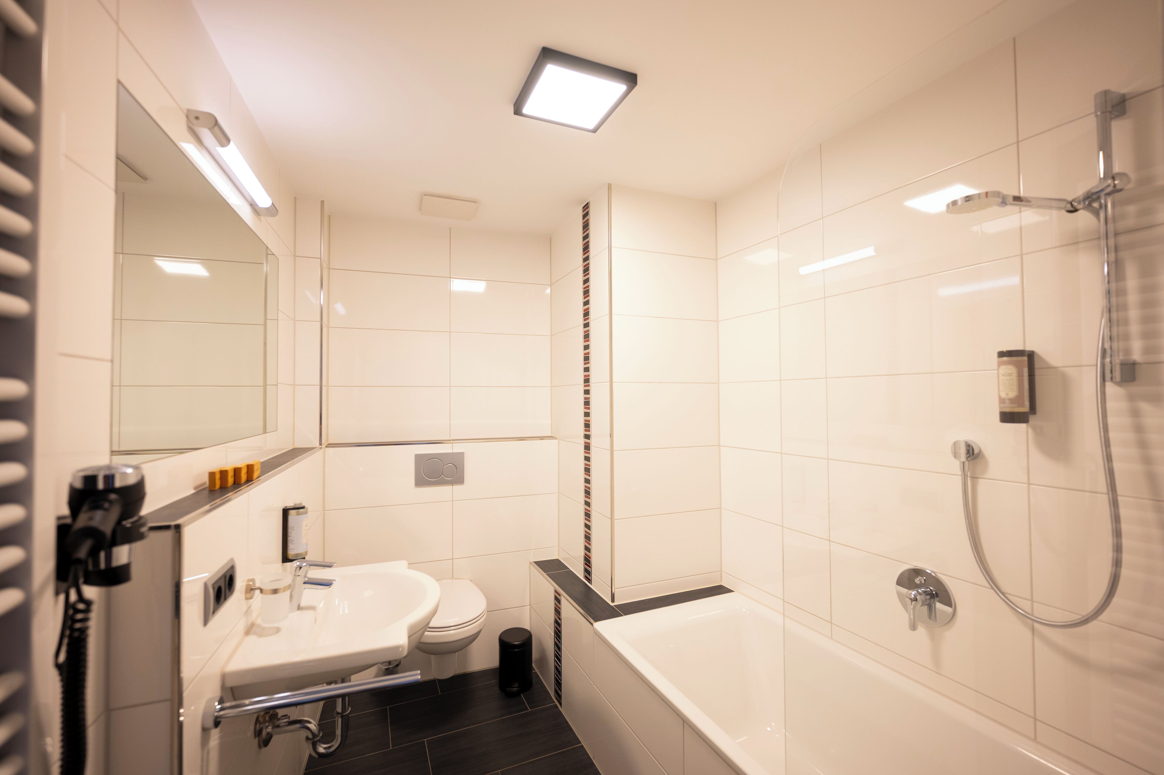 A modern bathroom with a bathtub, toilet, and sink.