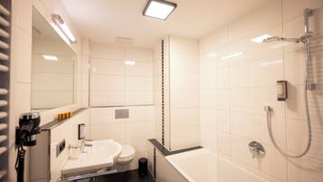 A modern bathroom with a bathtub, toilet, and sink.