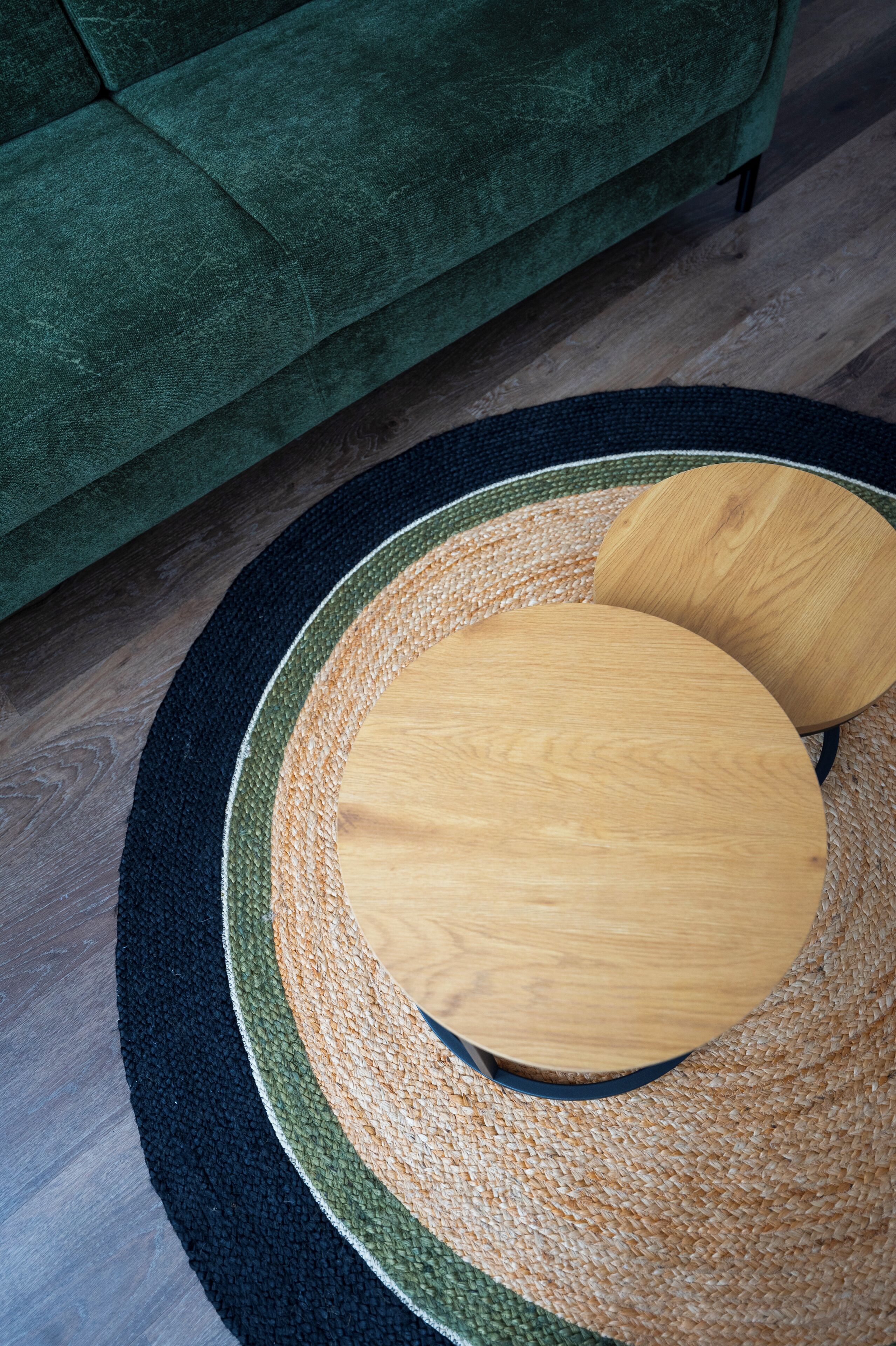 Una mesa redonda de madera con un tapete tejido debajo.