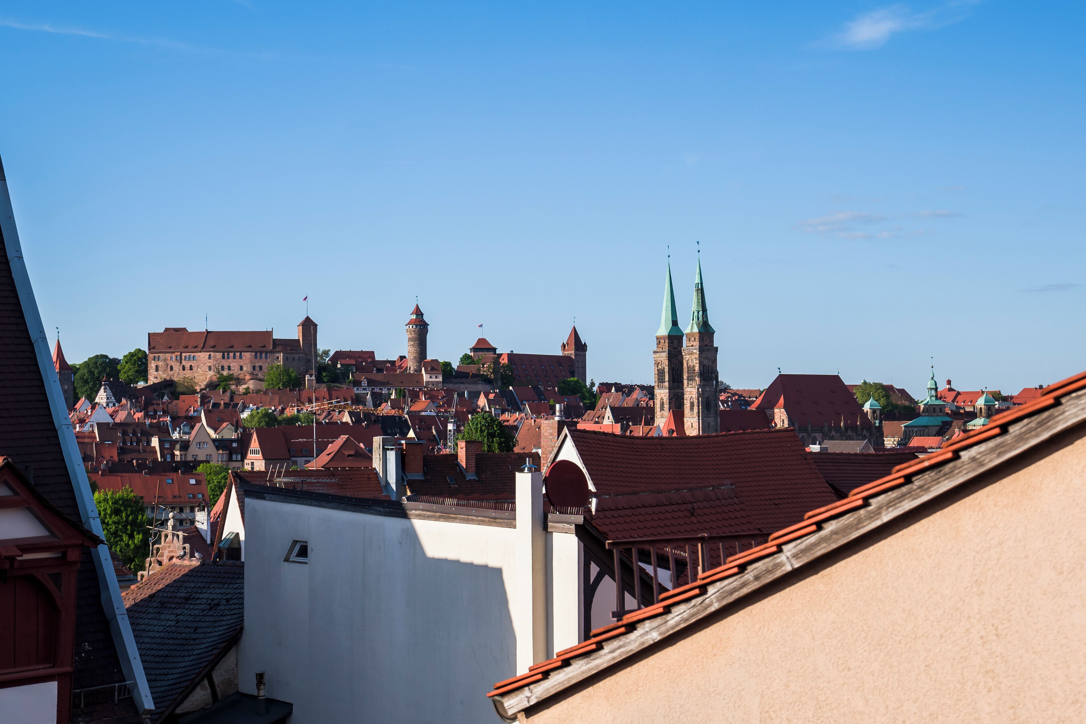 A historic town with red-roofed buildings and a prominent church with twin spires.