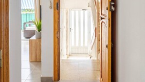 Un pasillo con una puerta de madera que da a una habitación con vista a un balcón.