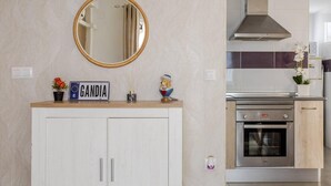 Una cocina con horno empotrado, extractor de acero inoxidable y encimera de madera con un espejo encima.