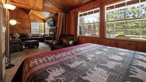 A cozy room with a large bed, a leather chair, a sofa, and a fireplace. - Chateau Rouge (Big Bear Lake)