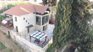 A two-story house with a red roof, a balcony with a pergola, and a large tree nearby. - Aley Maison des Couleurs - Artistic home in Aley's heart (Alay)